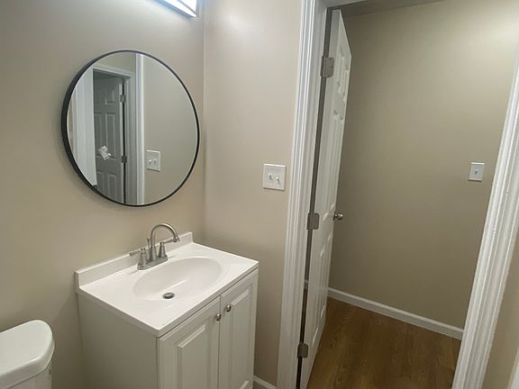 Beautifully refurbished bathroom featuring a stylish grey granite backsplash, modern fixtures, and sleek tiling throughout. The updated design combines elegance and functionality, creating a fresh and contemporary feel.