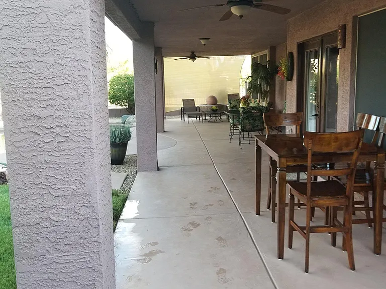 Expansive covered patio with comfortable patio furniture and two ceiling fans