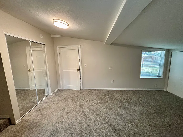 Spacious primary bedroom with mirrored closets and lots of extra storage