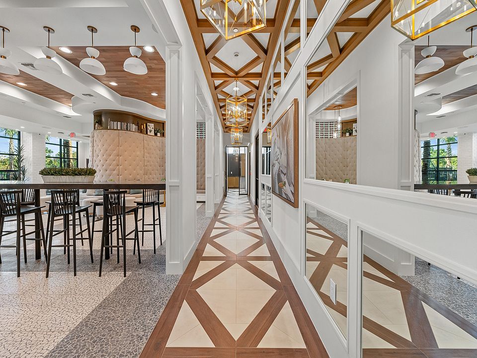 Elegant apartment hallway with stylish geometric flooring, modern lighting, and a chic open dining area.