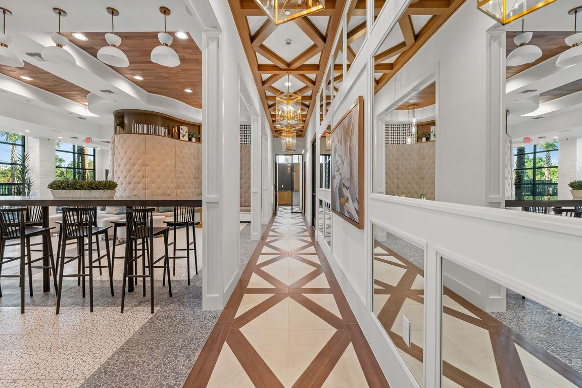 Elegant apartment hallway with stylish geometric flooring, modern lighting, and a chic open dining area.