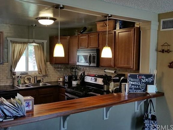 Different view of the kitchen with counter for bar stools or breakfast meals.
