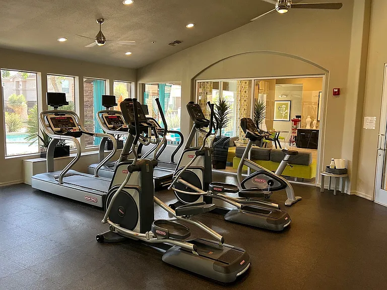 Spacious fitness center with state-of-the-art cardio equipment and poolside views.