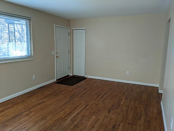 Your front door to living room with coat and large windows.