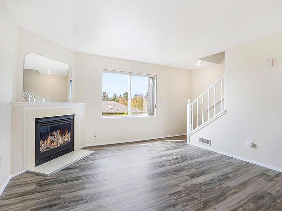 mirror image of living room with gas fireplace in unit A