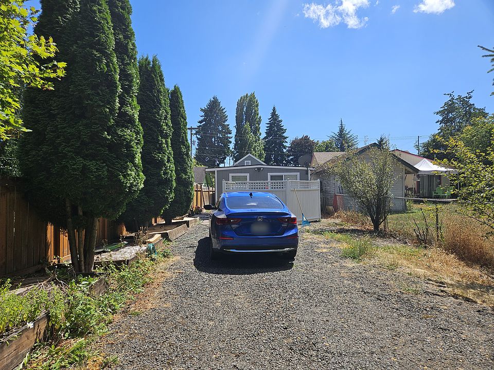 Large private driveway with ample natural light, and scenic trees.