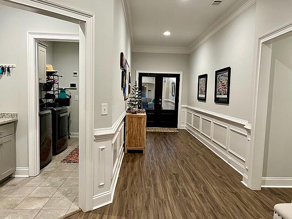 Mud room with lower cabinet storage, laundry room with utility sink through garage entrance