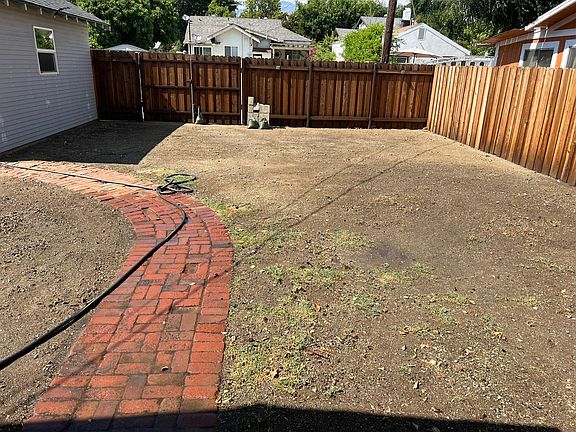 Backyard. Grass seed was recently distributed. Back Gate towards the alley. GARAGE NOT INCLUDED