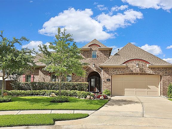 Another front view of this home highlights the pretty roof line peaks and archway entry to the home as well as the lovely contrasting c0lor of trim and exterior shutter.