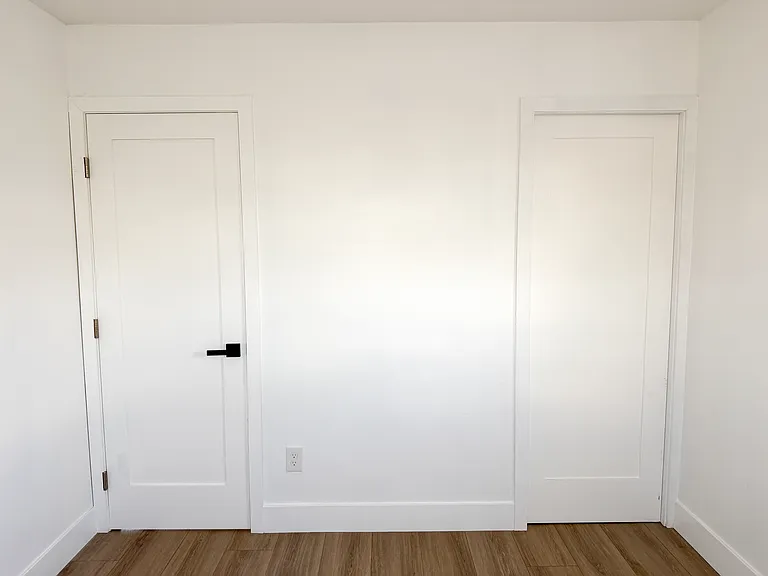 Bedroom 2. Entry door on the left and pocket door closet on the right.