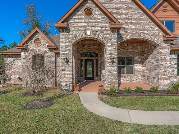 Walking up to the front door of the home you notice the front porch and gorgeous brick exterior.
