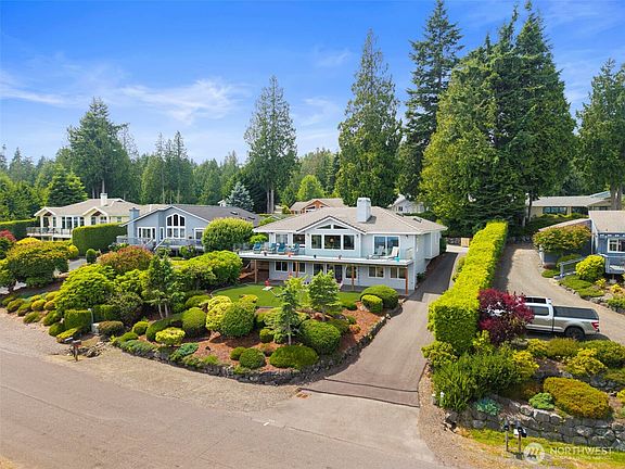 The newly paved driveway leads up to the garage at the front of the house. Low-maintenance landscaping is beautiful in every season. Note the off-street parking strip at the bottom of the property.>