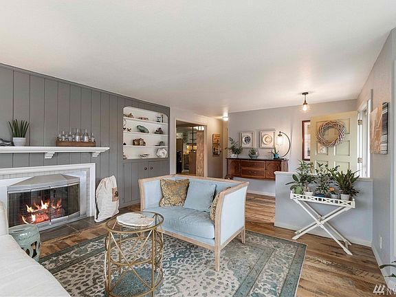 The living room shines with reclaimed wood floor, gas fireplace with mantle, built-in shelves and enormous bay windows that let in tons of natural light.