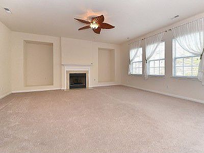Large family room with ceiling fan, gas fireplace and niches