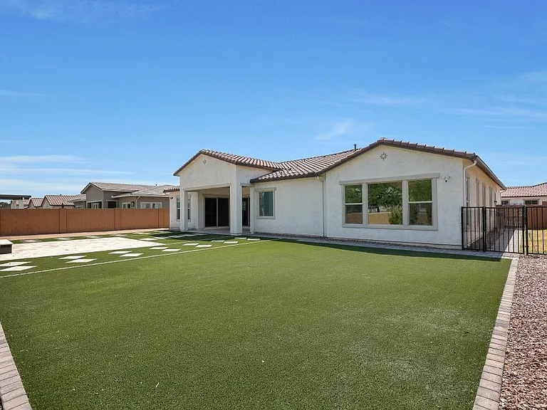 Backyard contains dog run behind gated fence.