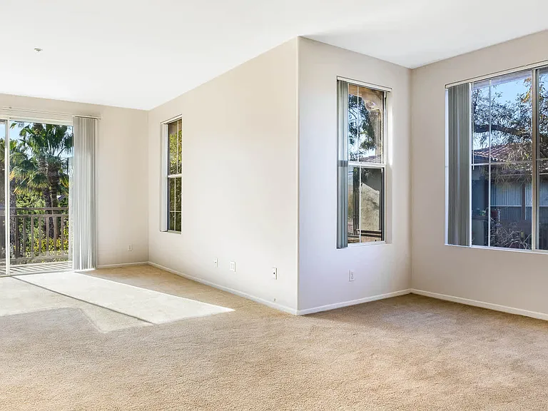Carpeted Living Room with Balcony