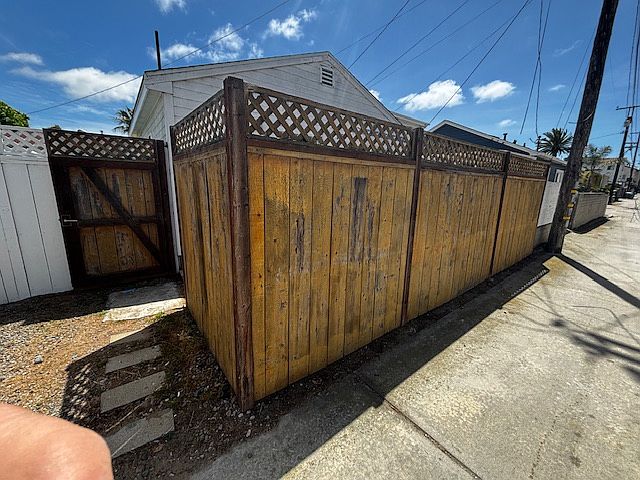 View shows entrance gate is open . The parking spot is right of entrance along the alley.The fence will be painted soon,