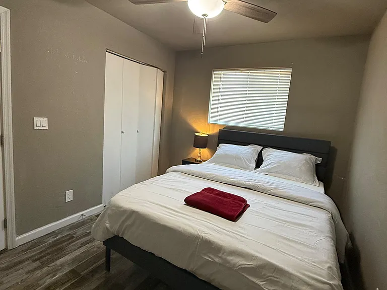 Private bedroom with a ceiling fan, large window with blinds, and a closet for convenient storage.