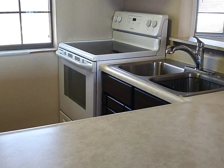 Kitchen with newer dishwasher, stove and refrigerator.
