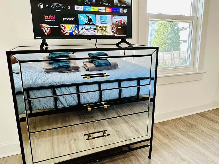 Primary Bedroom with King size bed, closet, dresser, two end tables and smart tv.