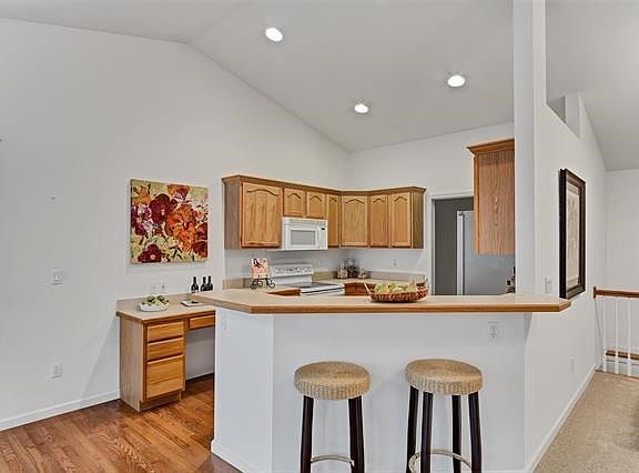 Vaulted kitchen with hardwood flooring.