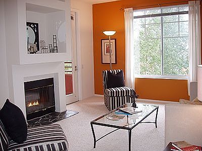 Spacious, light-filled living room with gas fireplace & bay view
