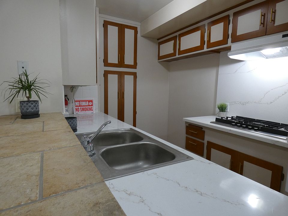 Part of the kitchen. Oven is to the right next to the cook-top. Bookshelves at the end of the counter, next to the dining area which is to the right of this photo.