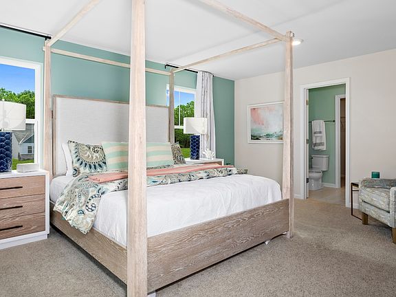 Carpeted owner s suite with 2 large windows in a DRB Homes Whitehall model home at The Village of C