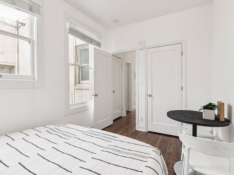 Bedroom with bed, comforter, pillows, and a small table with chairs