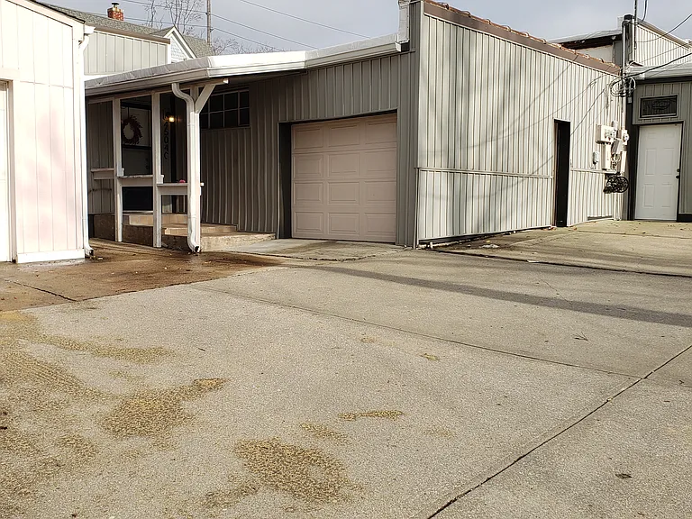 Front Door to apartment. Off Street parking is available. Laundry room door is on the right in this photo along the sage wall not the other garage door.