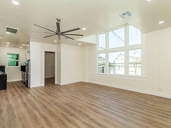 Large High Vaulted Ceiling with Custom Fan, Amazing Large Windows, Luxury Vinyl Plank Flooring, And Automatic Roll Down Shades.