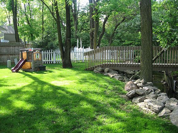lush backyard. Creek and bridge on property