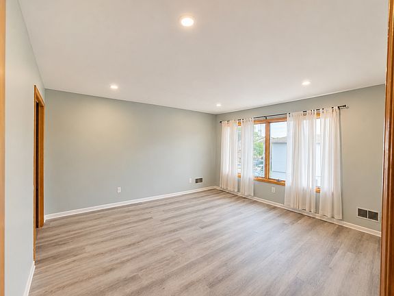 Large bedroom with modern flooring and recessed lighting