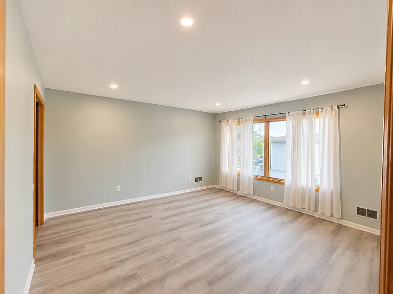 Large bedroom with modern flooring and recessed lighting