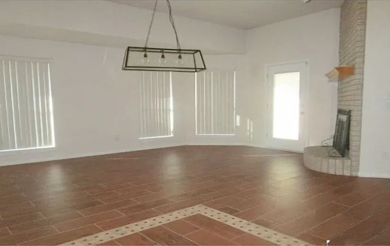 Large welcoming family room with fireplace and opens to covered patio and fenced backyard.