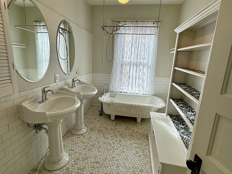 full bathroom with marble mosaic tile, original clawfoot tub, double sinks and ample storage
