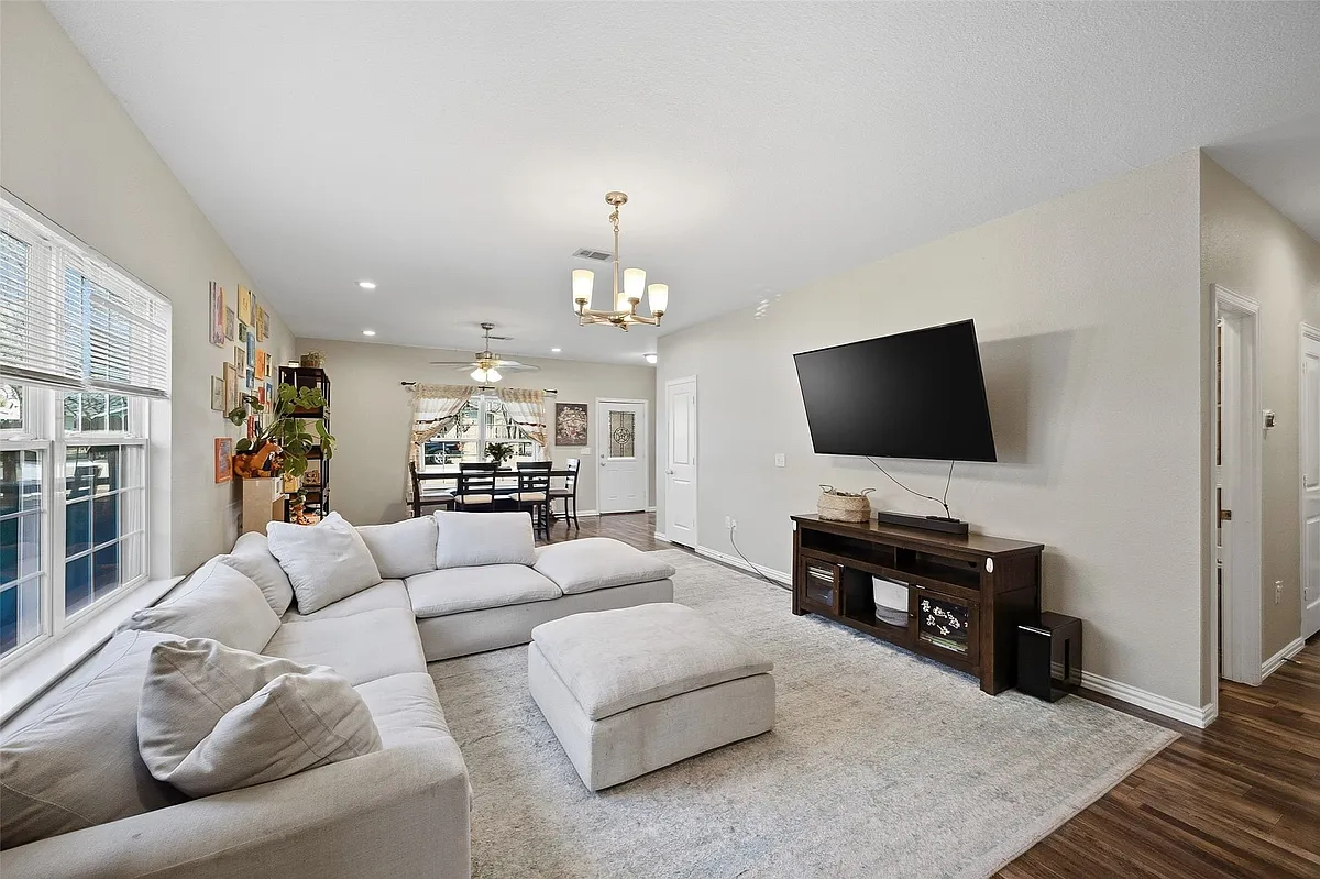 Open-concept living area featuring light-colored walls and wood-finish flooring - 3432 Frazier Ave