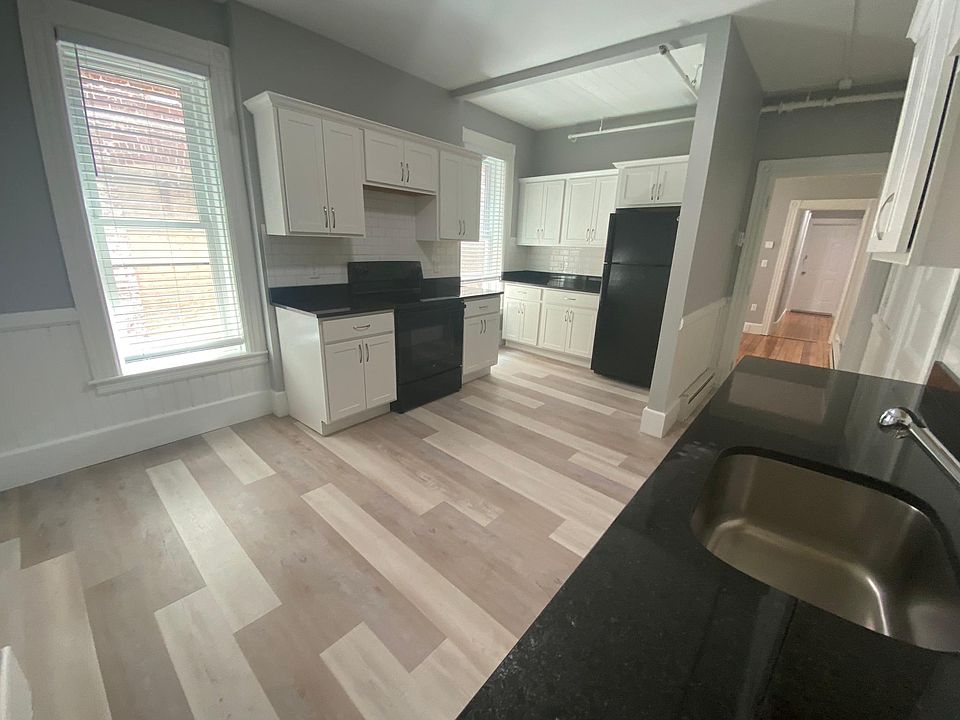 Large and spacious kitchen with black granite countertops on custom cabinets, white subway tile and new appliances