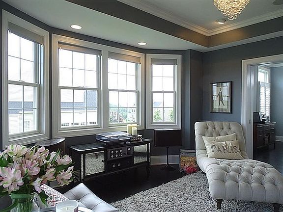 The gorgeous dining room features a bump-out bay with four windows and a set of French doors. The trayed ceiling and crown moldi