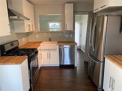 Kitchen and utility room behind with access to backyard.