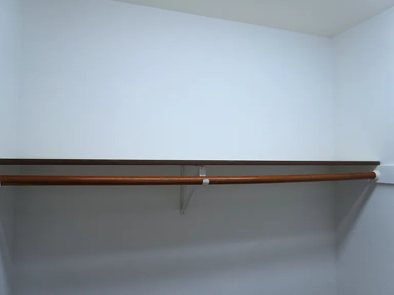 The master bedroom closet offers ample storage space, featuring two separate sections for organized storage, with one side shown here.