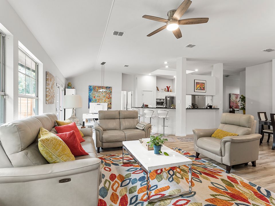 Open concept home with living, office, dining and kitchen all connected with high ceilings.