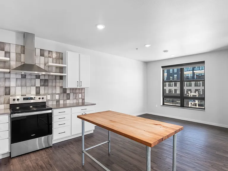 Modern kitchen featuring sleek stainless steel appliances, stylish backsplash, and a spacious wooden island in a bright open layout. Modern kitchen featuring sleek stainless steel appliances, stylish backsplash, and a spacious wooden island in a bright op