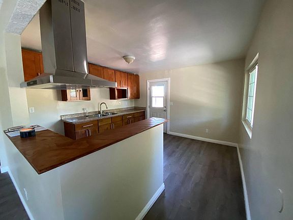 KITCHEN - STAINLESS STEEL RANGE VENT - PATIO DOOR LEADS TO BACKYARD AND LAUNDRY ROOM