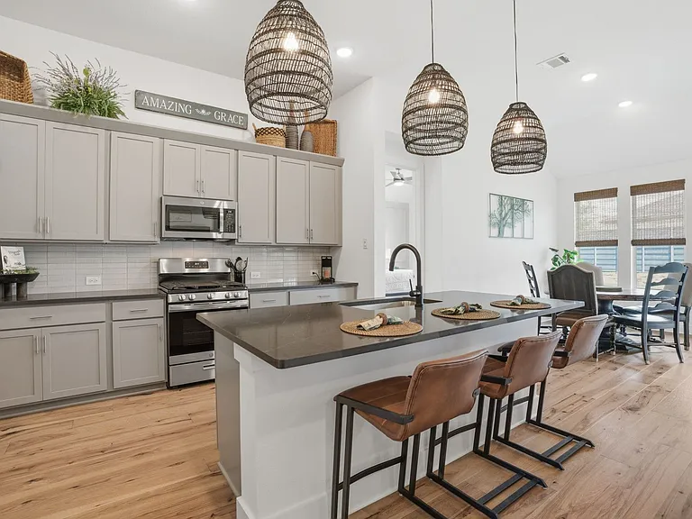 Upgraded pendant lights over the kitchen island are among the decorator touches in this home that make it one of a kind!