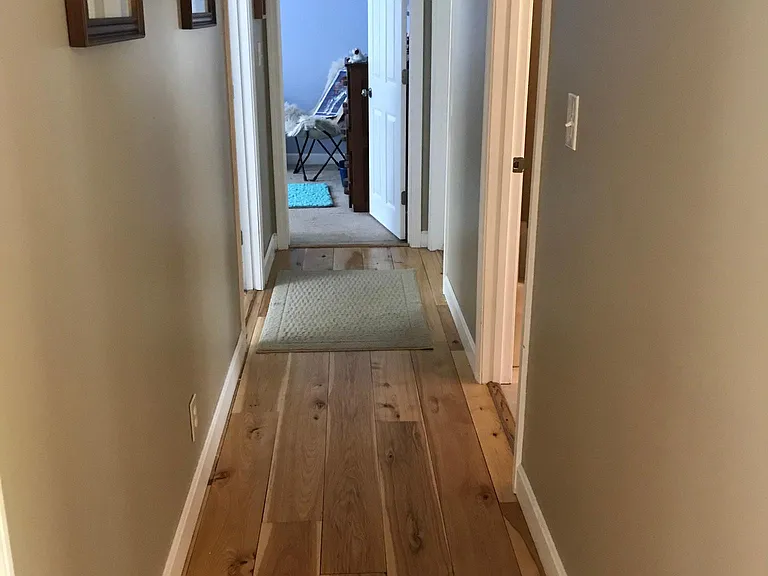 Upstairs hardwood hallway to 3 bedrooms, a bath, a closet, and "drop-down" storage.
