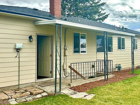 Rear pic of home showing garage mandoor and access to basement.