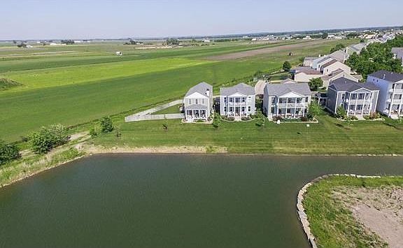 Aerial view from the lake looking to the front of the house. Unobstructed views to enjoy the morning sunrise and evening moonrise from the rear of the home and the gorgeouse sunsets from the enjoyment of the double balcony or beautifully maintained lakefr