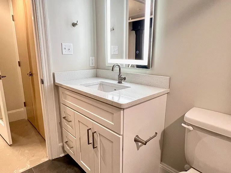 Primary bath, view of the vanity out to the bedroom "foyer", showing spacious closet in the back of the photo.