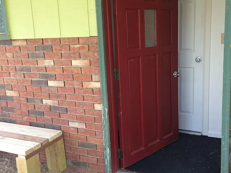 Common red door toward the apartment door and laundry room
